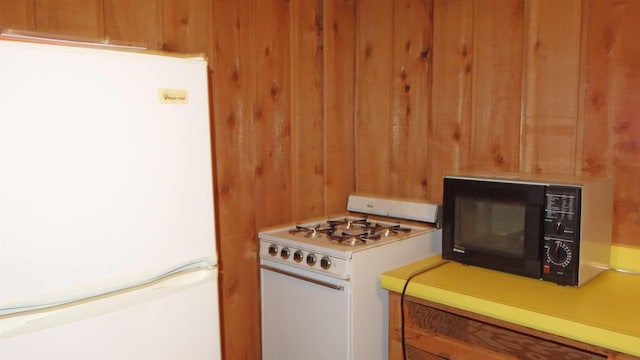 kitchen with wooden walls and white appliances