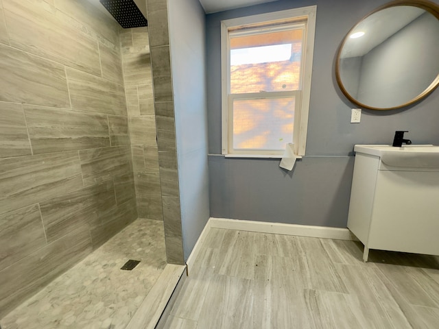 bathroom featuring tiled shower and vanity