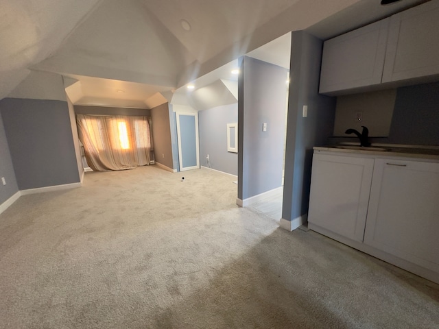 bonus room with light colored carpet, vaulted ceiling, and sink