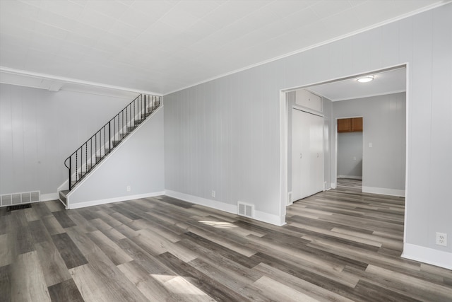 unfurnished living room featuring crown molding and dark hardwood / wood-style flooring