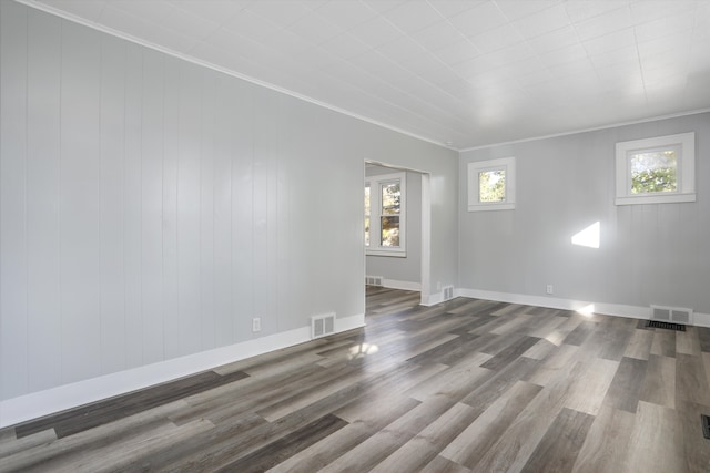 spare room featuring crown molding and dark wood-type flooring