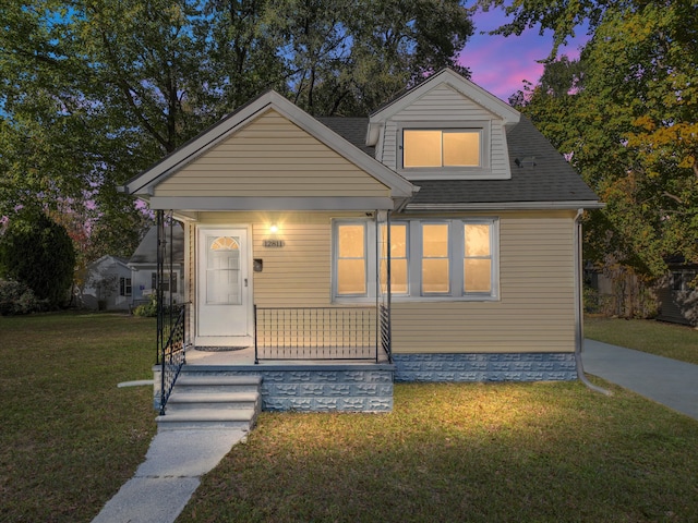 bungalow featuring a porch and a lawn