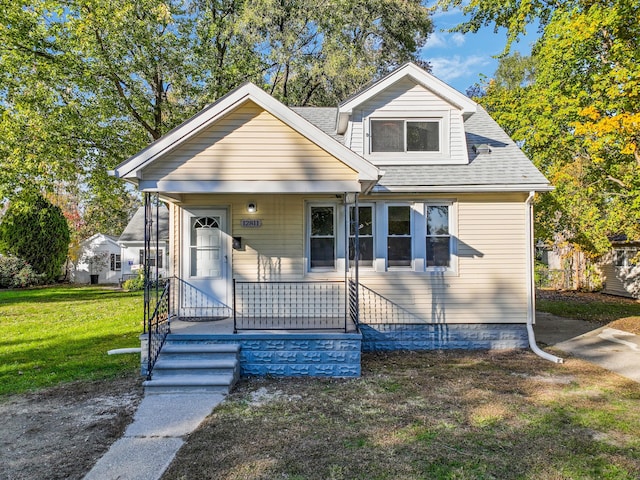 bungalow-style house featuring covered porch and a front lawn