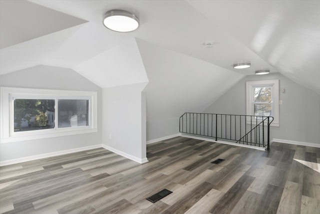 bonus room with dark hardwood / wood-style flooring and vaulted ceiling