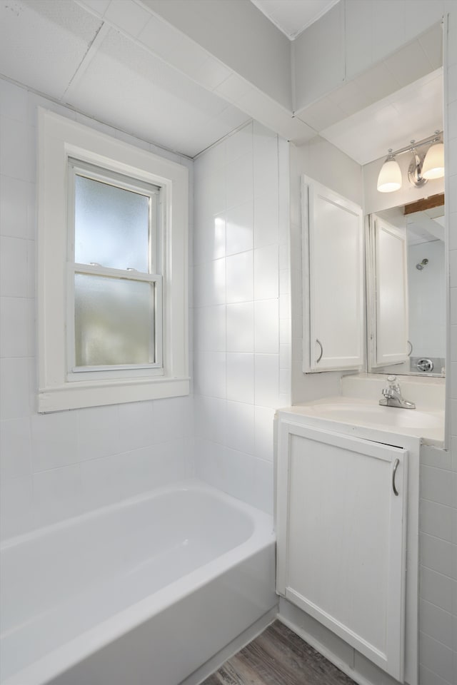 bathroom with vanity, tile walls, and hardwood / wood-style flooring