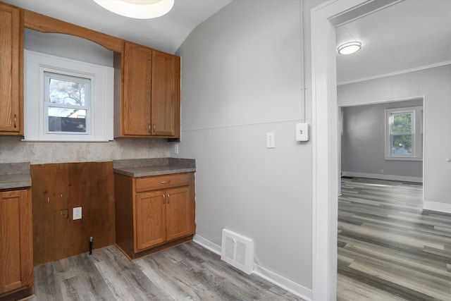 kitchen featuring decorative backsplash, light hardwood / wood-style flooring, and ornamental molding