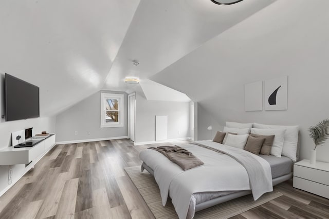 bedroom featuring vaulted ceiling and light hardwood / wood-style flooring