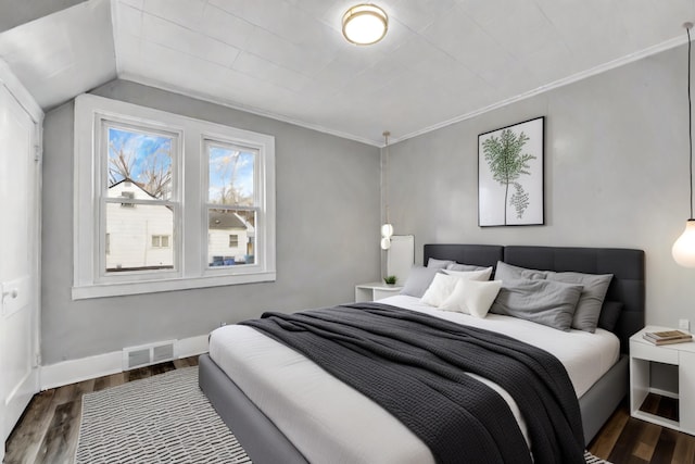 bedroom with dark hardwood / wood-style floors, crown molding, and vaulted ceiling