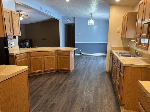 kitchen featuring pendant lighting, sink, dark hardwood / wood-style floors, a baseboard radiator, and kitchen peninsula