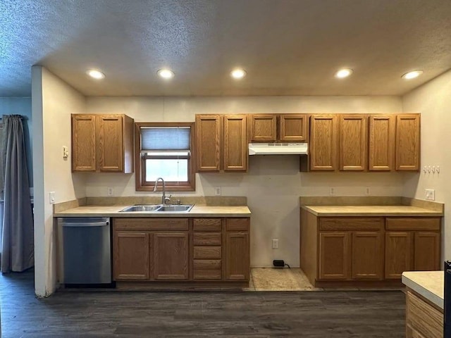 kitchen with a textured ceiling, stainless steel dishwasher, dark wood-type flooring, and sink