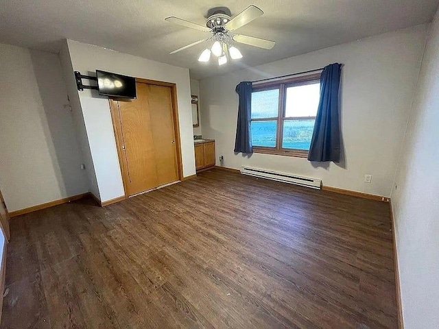 unfurnished bedroom with baseboard heating, ceiling fan, a closet, and dark hardwood / wood-style floors