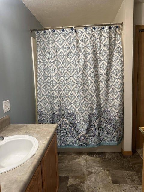 bathroom featuring shower / tub combo, vanity, and a textured ceiling