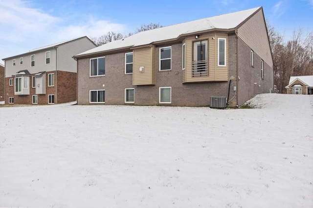 snow covered property with central air condition unit