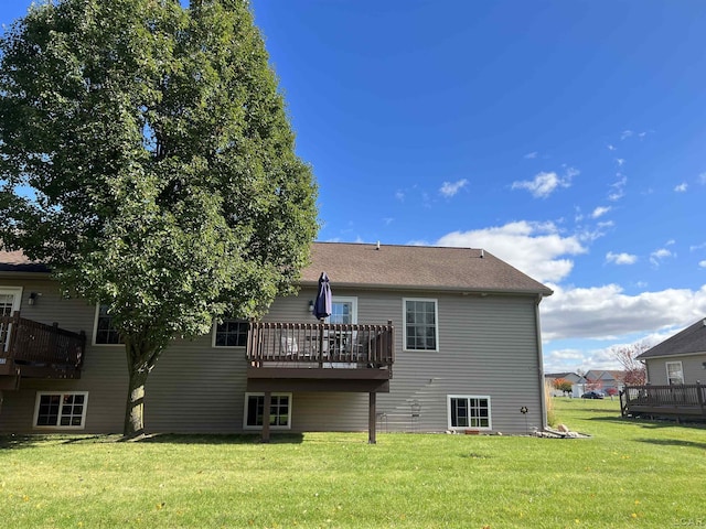 back of property with a deck and a yard