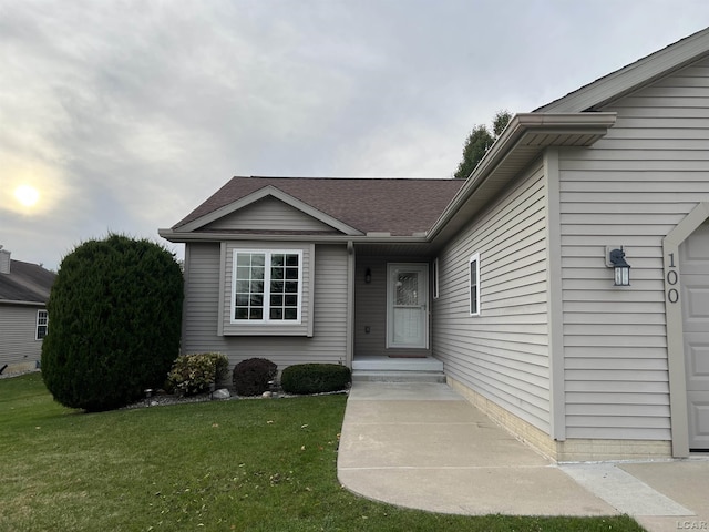 view of exterior entry with a lawn