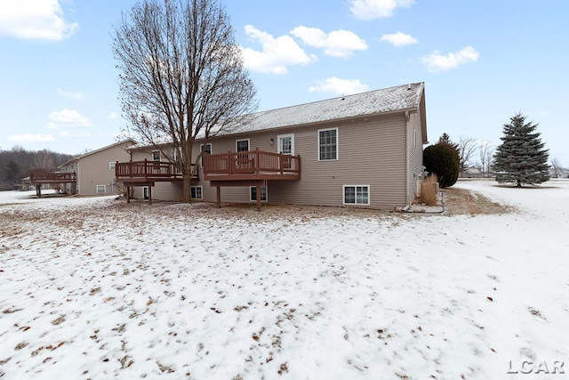 snow covered property with a deck