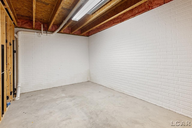 basement featuring brick wall