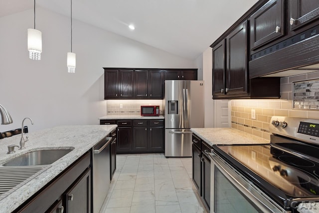 kitchen featuring pendant lighting, backsplash, vaulted ceiling, appliances with stainless steel finishes, and dark brown cabinetry