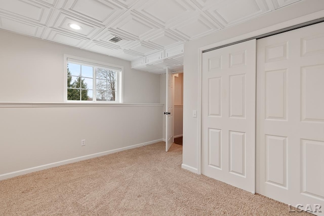 unfurnished bedroom with light carpet and a closet