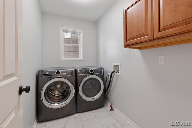 laundry room with separate washer and dryer and cabinets