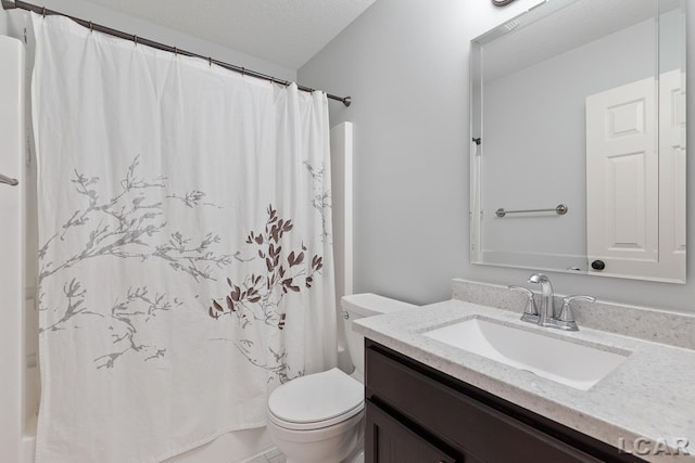 bathroom with vanity, toilet, and a textured ceiling