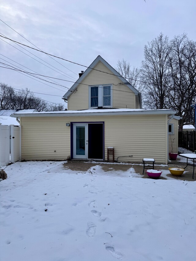 view of snow covered back of property