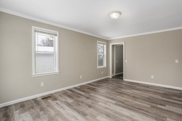 empty room featuring hardwood / wood-style floors and crown molding