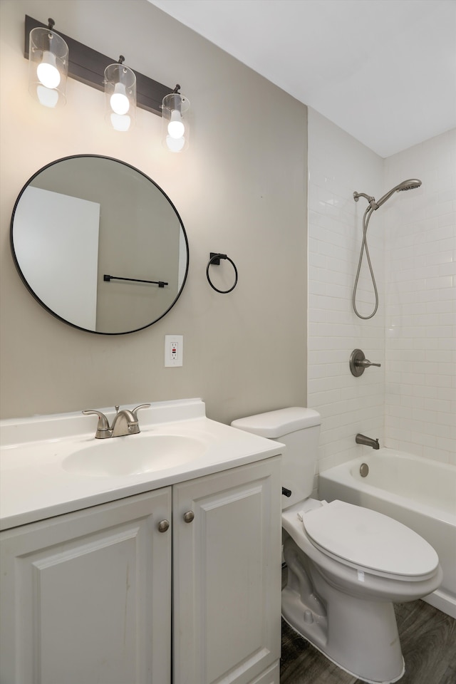 full bathroom featuring toilet, wood-type flooring, vanity, and tiled shower / bath