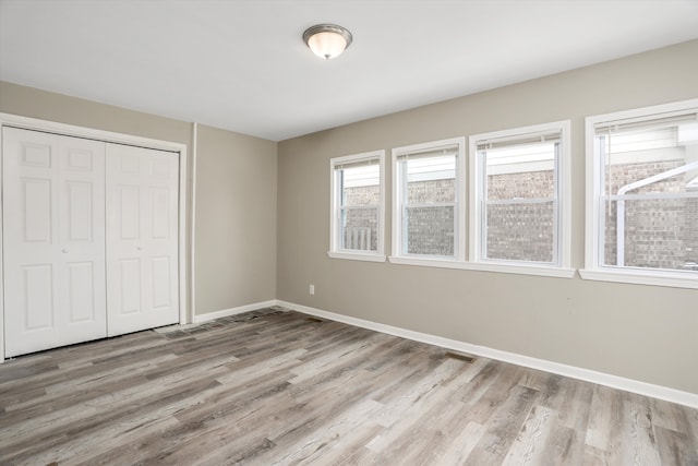 unfurnished bedroom featuring a closet and light wood-type flooring