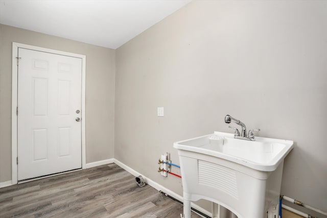 laundry area with sink and hardwood / wood-style floors