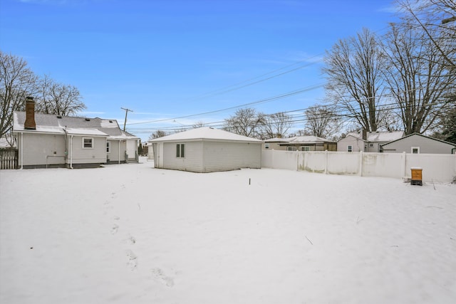 view of snow covered back of property