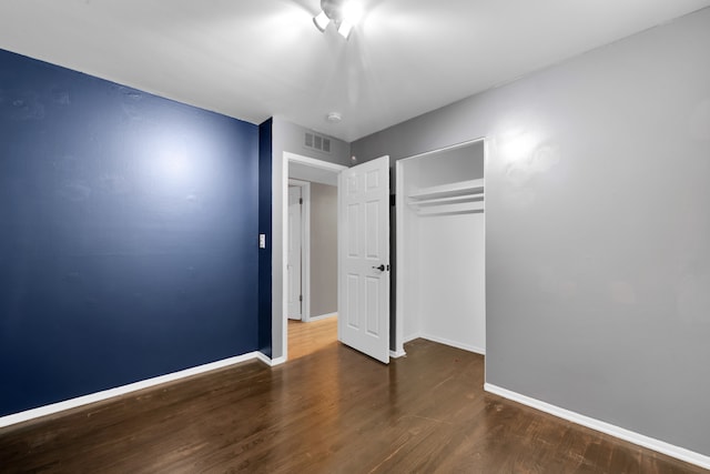 unfurnished bedroom featuring dark wood-type flooring and a closet