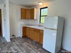 4433 Brighton Rd, Howell, MI 48843 - kitchen with a sink, brown cabinets, freestanding refrigerator, and light countertops
