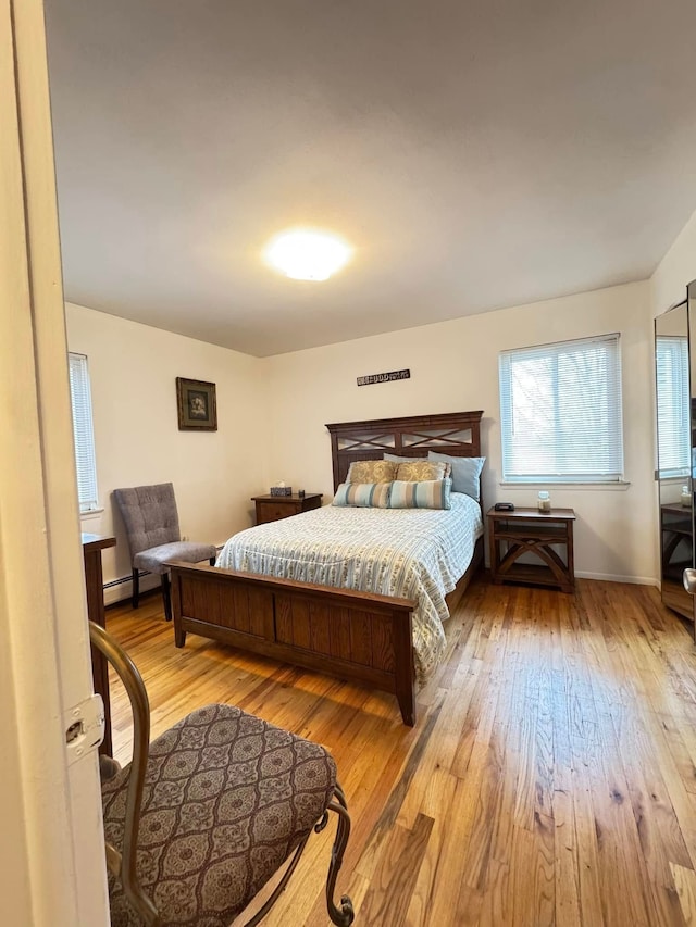 bedroom featuring light wood-type flooring and baseboard heating