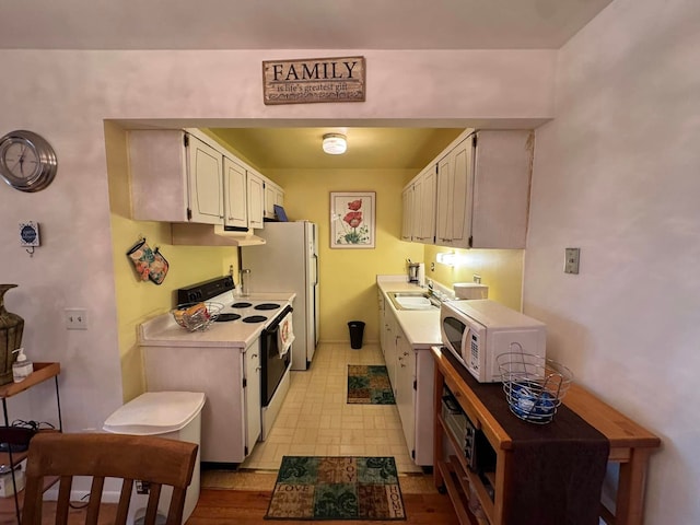 kitchen with white cabinets, white appliances, and sink