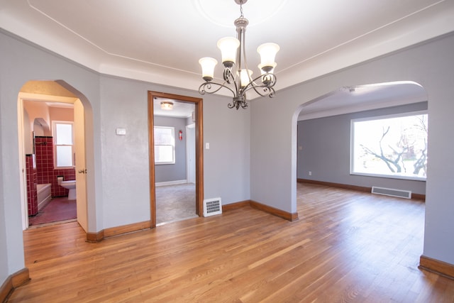 unfurnished room featuring hardwood / wood-style floors and an inviting chandelier