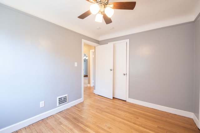 unfurnished bedroom featuring light hardwood / wood-style floors, ceiling fan, and crown molding