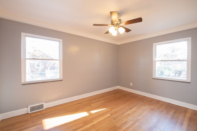 unfurnished room featuring crown molding, hardwood / wood-style floors, ceiling fan, and a healthy amount of sunlight