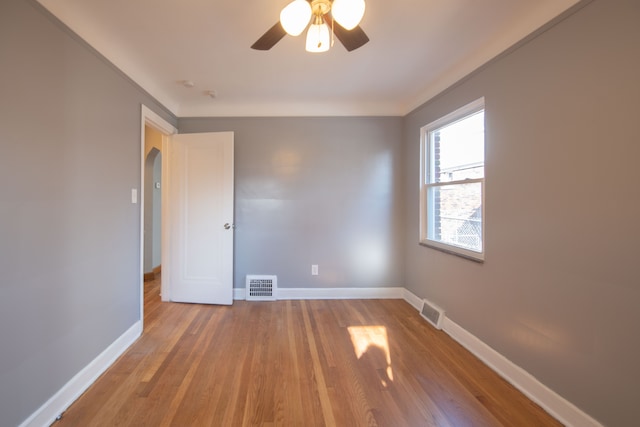 unfurnished room with ceiling fan, light hardwood / wood-style flooring, and crown molding