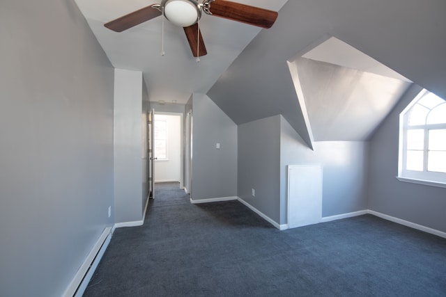 bonus room featuring ceiling fan, dark carpet, vaulted ceiling, and a baseboard heating unit