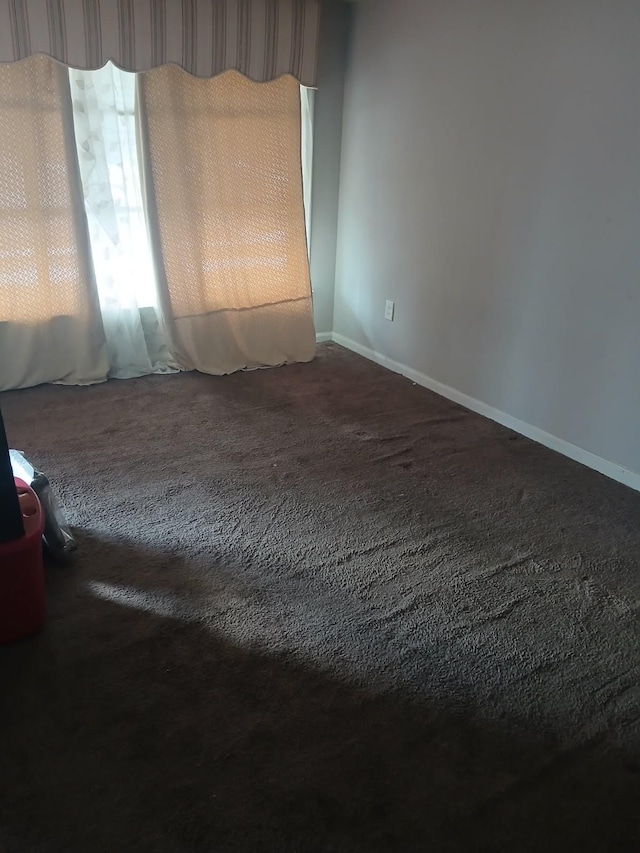 carpeted spare room with baseboards