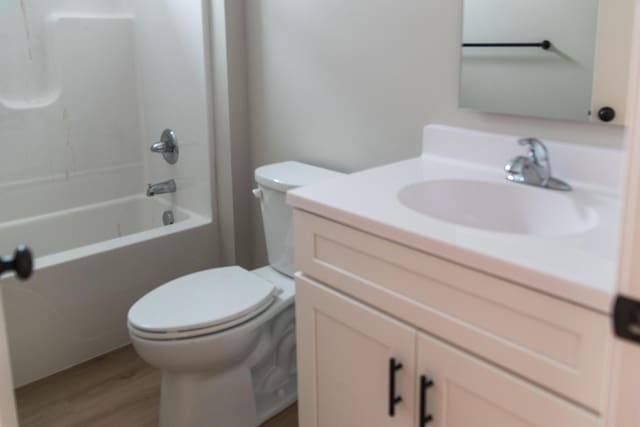 full bathroom featuring vanity, shower / bathing tub combination, wood-type flooring, and toilet