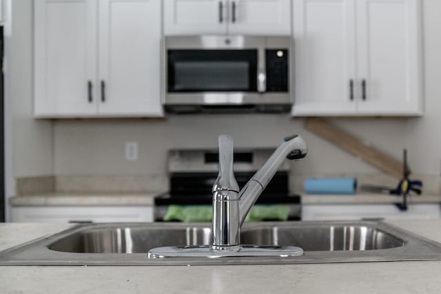 kitchen featuring white cabinets and sink