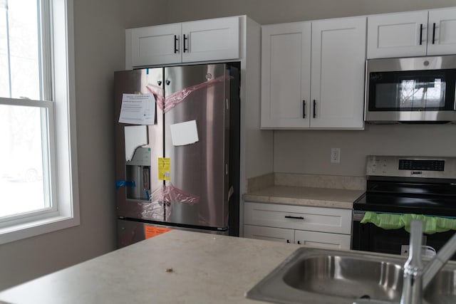 kitchen with white cabinetry, sink, and appliances with stainless steel finishes