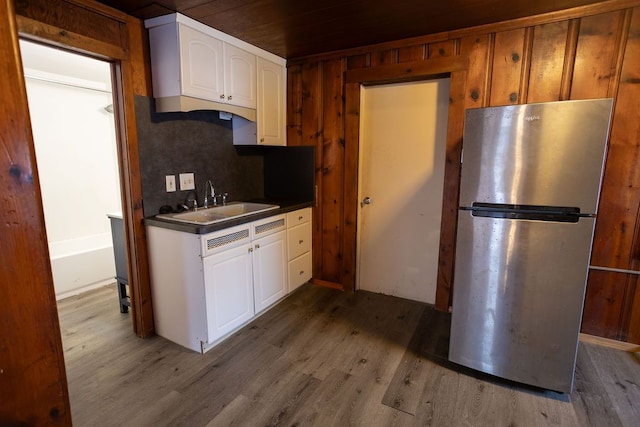 kitchen with stainless steel fridge, dark wood-type flooring, decorative backsplash, white cabinets, and sink