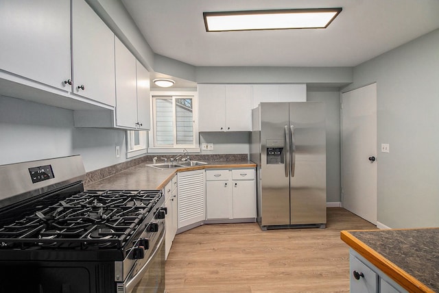 kitchen with stainless steel appliances, light hardwood / wood-style flooring, white cabinets, and sink