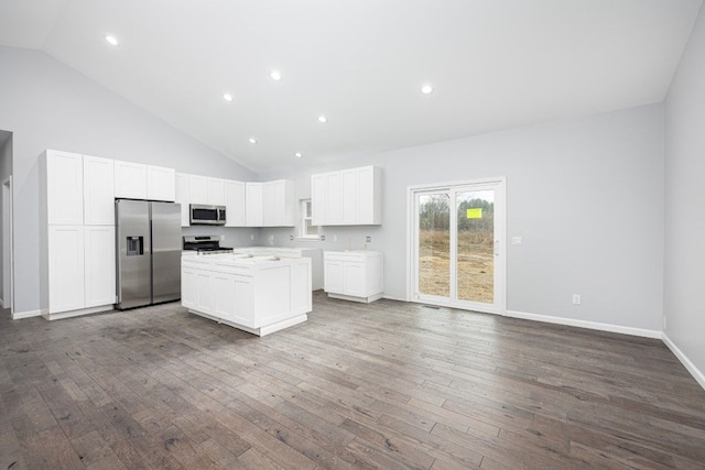 kitchen with a kitchen island, stainless steel appliances, high vaulted ceiling, white cabinets, and dark hardwood / wood-style flooring