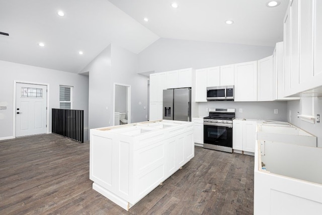 kitchen with white cabinets, dark hardwood / wood-style floors, stainless steel appliances, and a center island