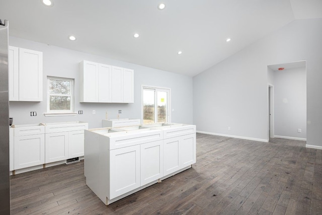 kitchen with vaulted ceiling, dark hardwood / wood-style floors, and white cabinets