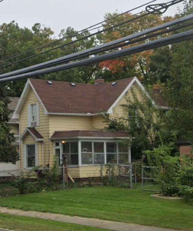 view of front facade featuring a front yard and a sunroom